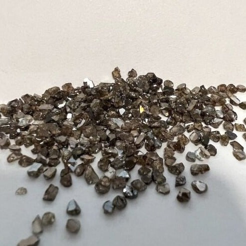 Mehrere lose Diamantsplitter in unterschiedlichen Größen auf hellem Untergrund